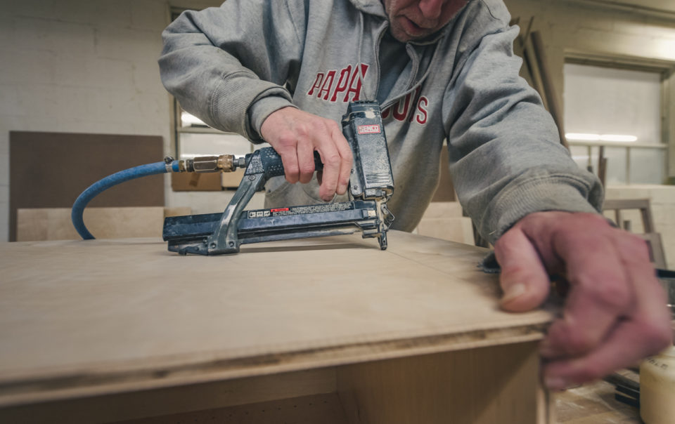 Image of a worker with an pneumatic finish nail gun